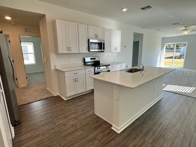 a kitchen with wooden floors and white cabinets