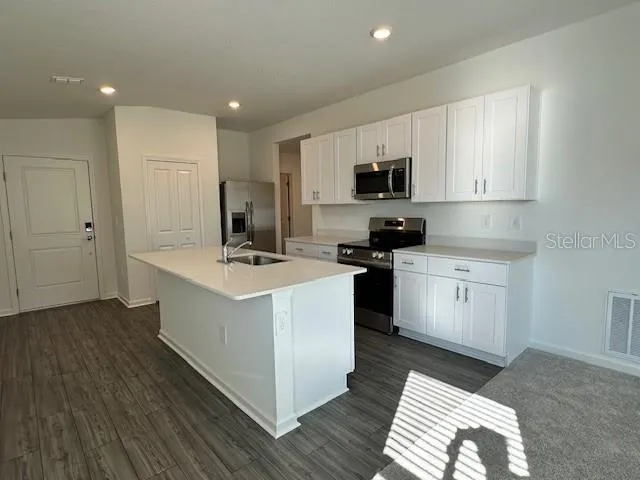 a kitchen with a sink stove and refrigerator