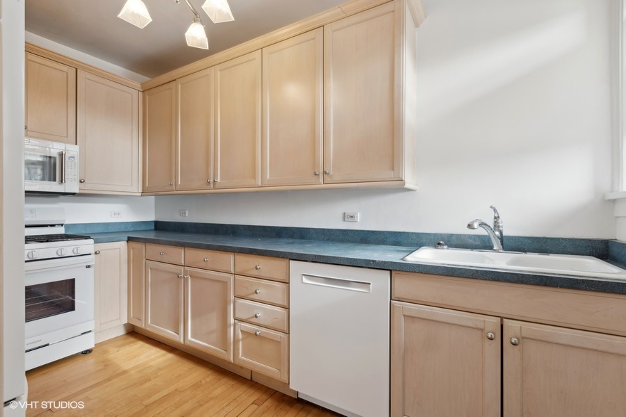 478 Sheridan Road, Unit 2 Evanston, IL 60202 - Photo 10 of 16 a kitchen with granite countertop white cabinets and white appliances