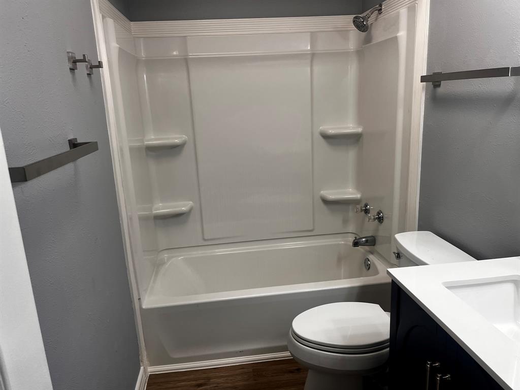 1007 Mack Place Denton, TX 76209 - Photo 37 of 37 Full bath with a textured wall, vanity, dark wood-style flooring, and shower / washtub combination