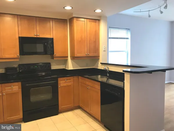 a kitchen with granite countertop a sink stove and microwave