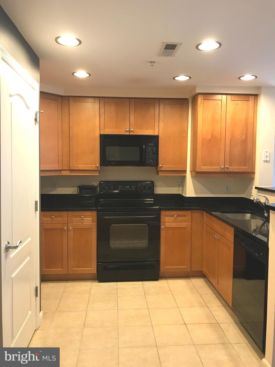 1111 11th Street Northwest, Unit 510 Washington, DC 20001 - Photo 8 of 13 a kitchen with stainless steel appliances granite countertop a stove a sink and a microwave