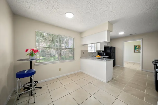 a kitchen with stainless steel appliances kitchen island granite countertop a refrigerator and a sink