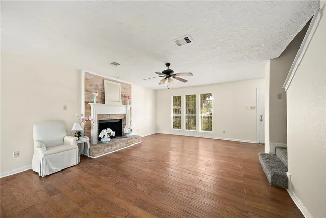 a view of a livingroom with furniture a fireplace and wooden floor