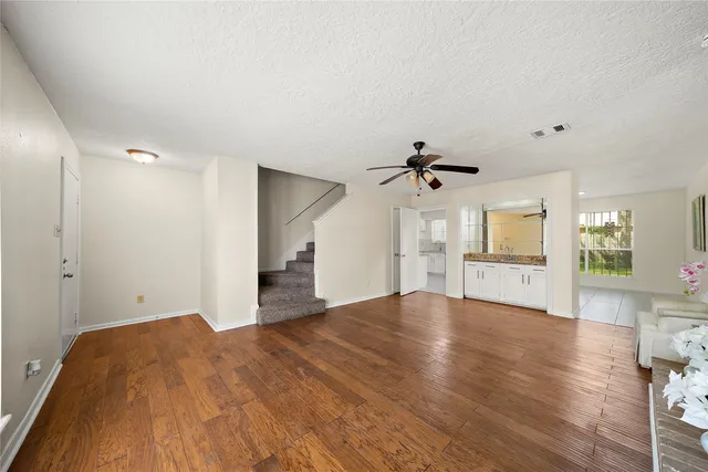 a view of empty room with wooden floor and windows