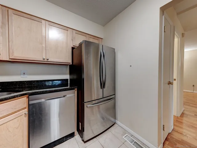 a metallic refrigerator freezer sitting inside of a kitchen