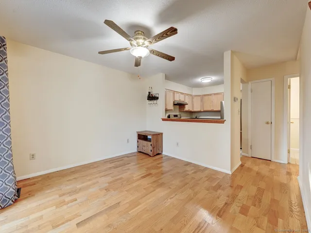 a view of a kitchen with wooden floor and a ceiling fan