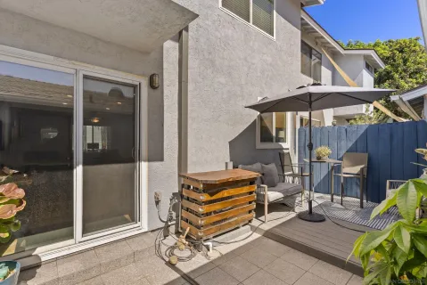 a patio with a table and chairs under an umbrella