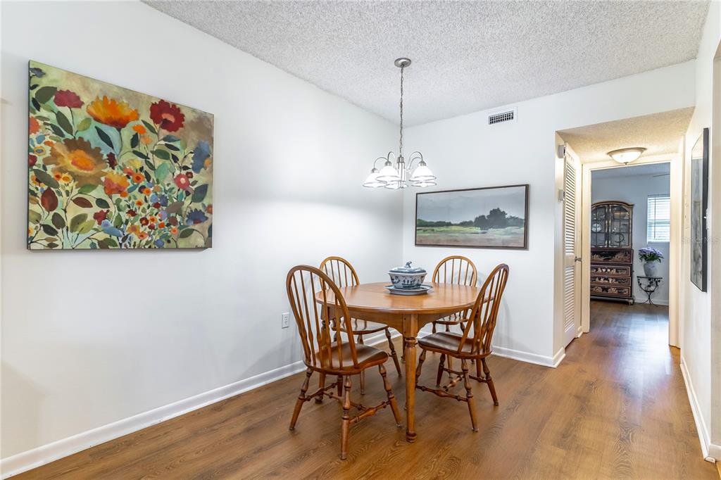 2500 Lee Road, Unit 243 Winter Park, FL 32789 - Photo 11 of 28 a view of a dining room with furniture wooden floor and a chandelier