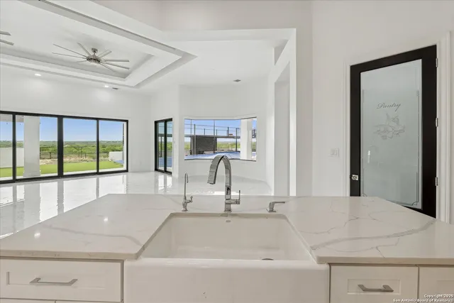 a view of a room with a ceiling fan and a white walls