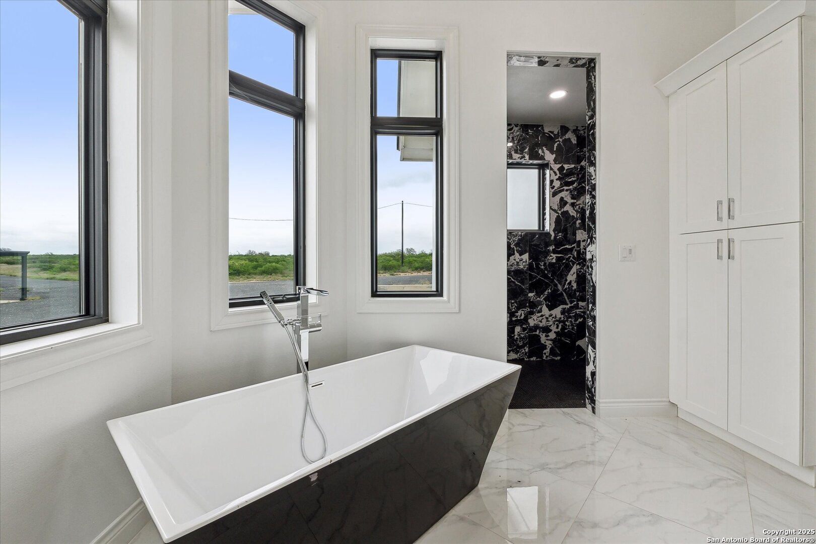 1799 County Road 651 Devine, TX 78016 - Photo 30 of 72 a white bath tub sitting in a bathroom next to a window