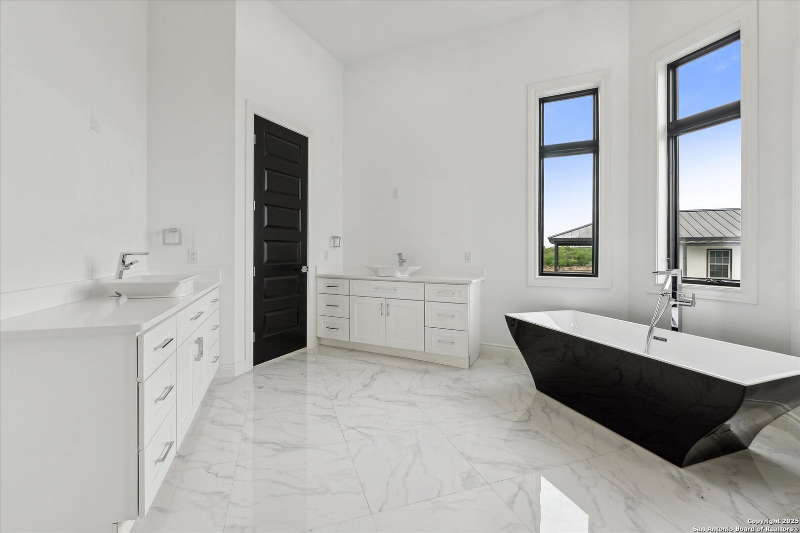 1799 County Road 651 Devine, TX 78016 - Photo 31 of 72 a spacious bathroom with a double vanity sink a mirror and a bathtub