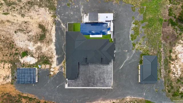 an aerial view of residential houses with outdoor space and ocean view