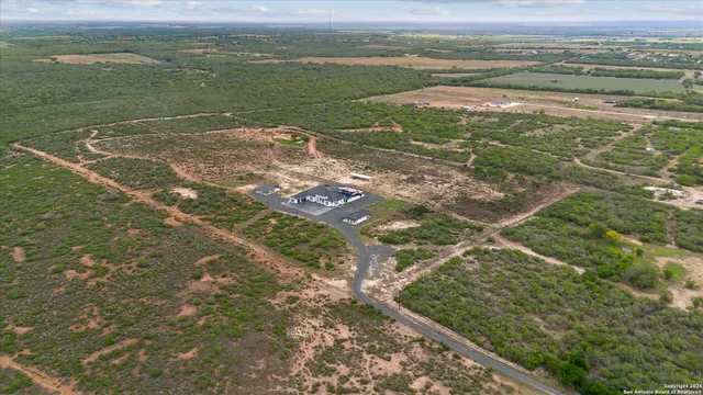 an aerial view of a house with a yard and furniture