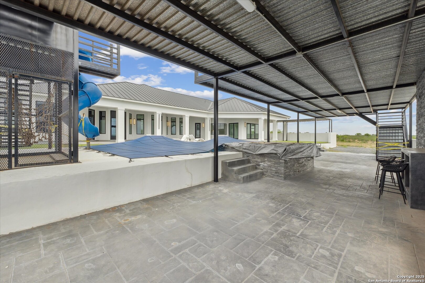 1799 County Road 651 Devine, TX 78016 - Photo 49 of 72 a view of a patio with table and chairs under an umbrella