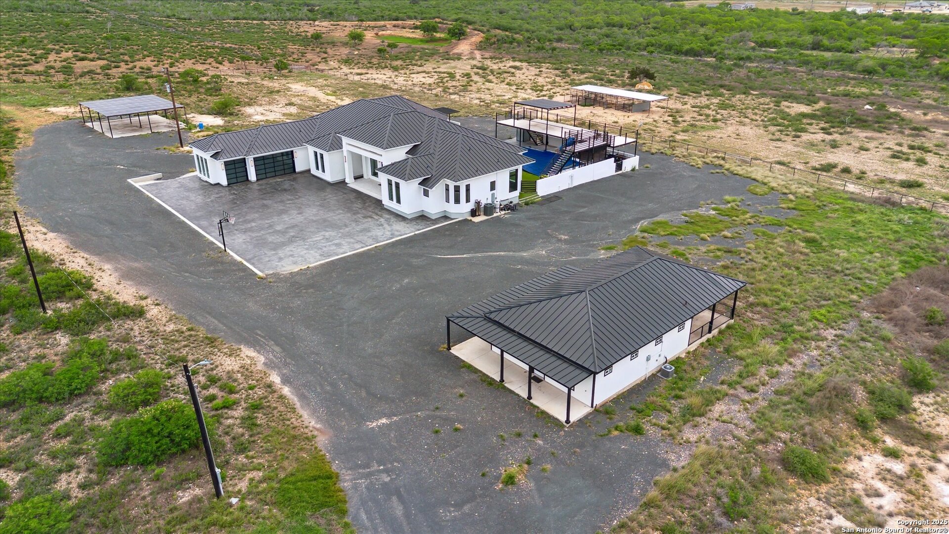 1799 County Road 651 Devine, TX 78016 - Photo 54 of 72 an aerial view of residential houses with outdoor space and swimming pool