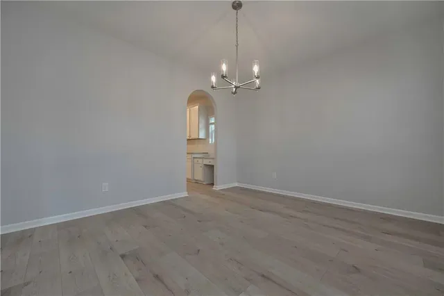 a view of a room with a chandelier fan and wooden floor