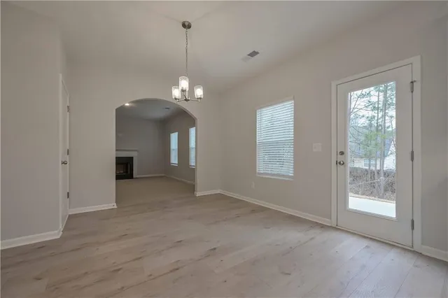 a view of a livingroom with a chandelier fan and a window