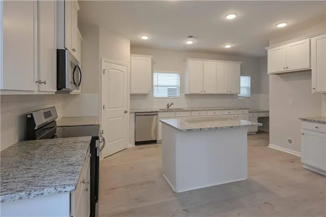 a kitchen with stainless steel appliances granite countertop a sink stove and refrigerator