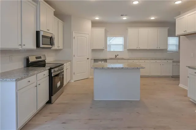a kitchen with a sink stove cabinets and refrigerator