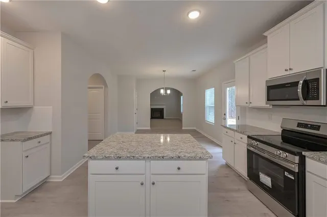 a kitchen with granite countertop stainless steel appliances and white cabinets