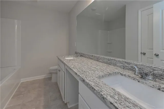 a bathroom with a granite countertop sink and toilet
