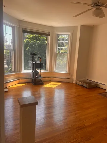 a view of a room with wooden floor and a window