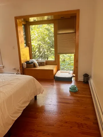 a bed sitting in a bedroom next to a window