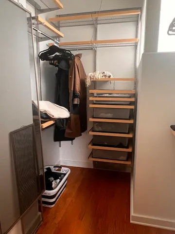 a view of walk in closet with clothes and shoes