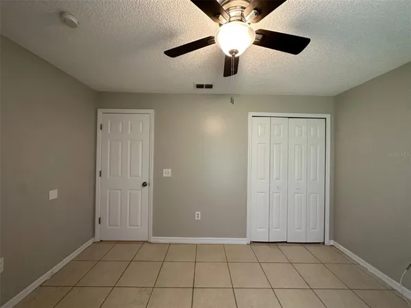 an empty room with fan and windows