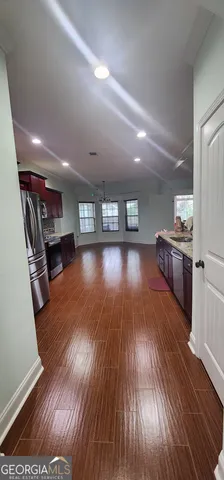 a living room with stainless steel appliances furniture and a kitchen view