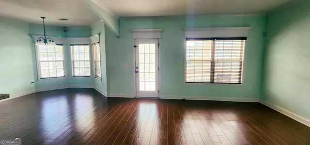 a view of a livingroom with a fireplace a ceiling fan and windows