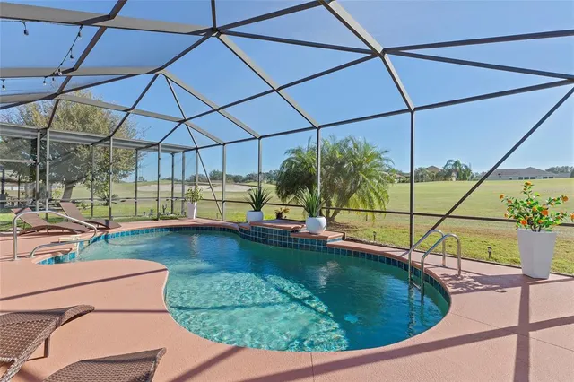 a view of a swimming pool with a yard and sitting area