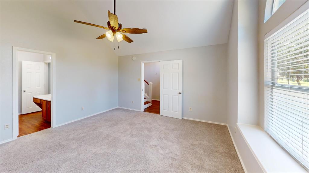 7913 Rice Drive Rowlett, TX 75088 - Photo 12 of 25 Neutral carpeted room featuring a ceiling fan, light gray walls, and multiple windows with white blinds
