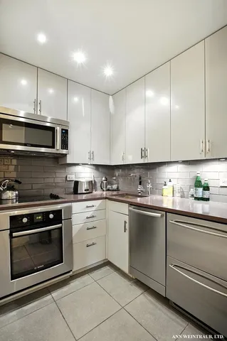 a kitchen with granite countertop cabinets stainless steel appliances and a sink