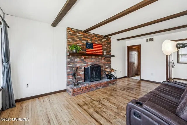 a view of a livingroom with wooden floor and a fireplace