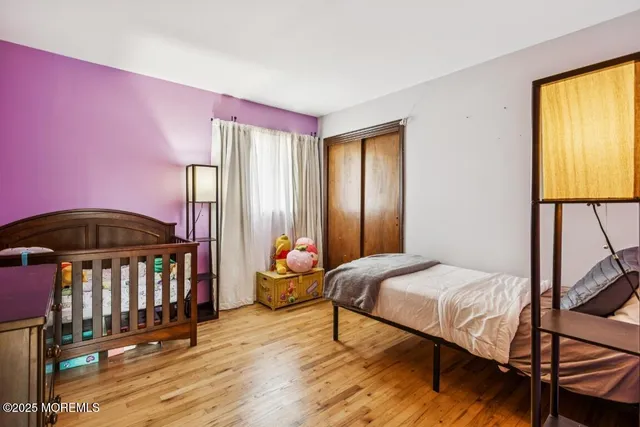 a bedroom with a bed a dresser and windows