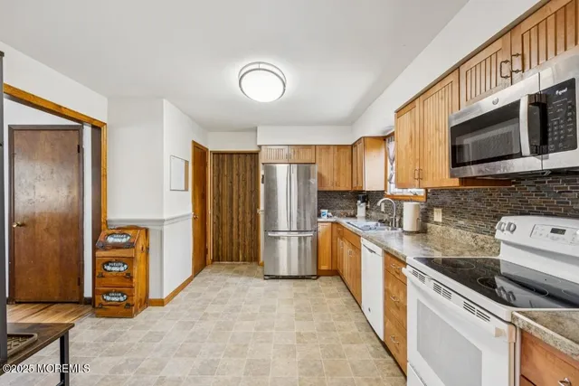 a kitchen with stainless steel appliances granite countertop a refrigerator and a stove top oven