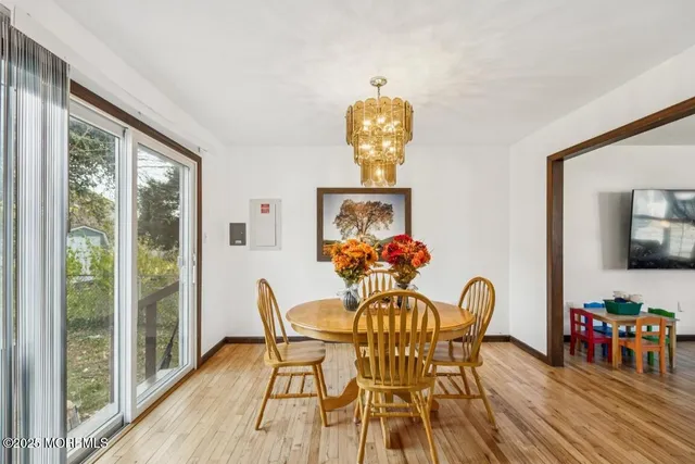 a view of a dining room with furniture a chandelier and wooden floor