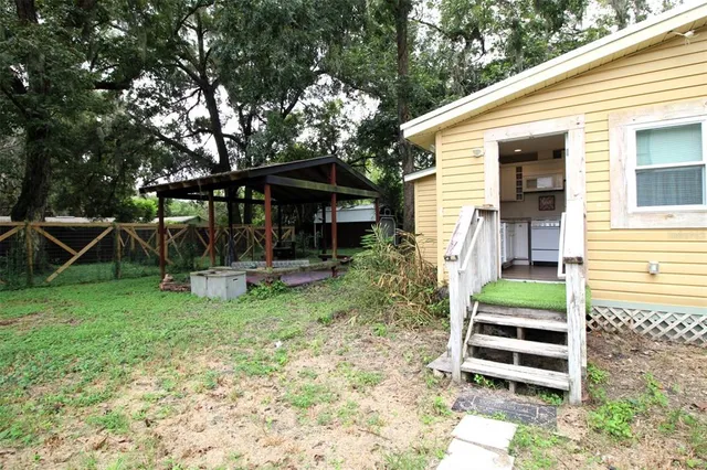 a view of a chair and table in backyard of the house