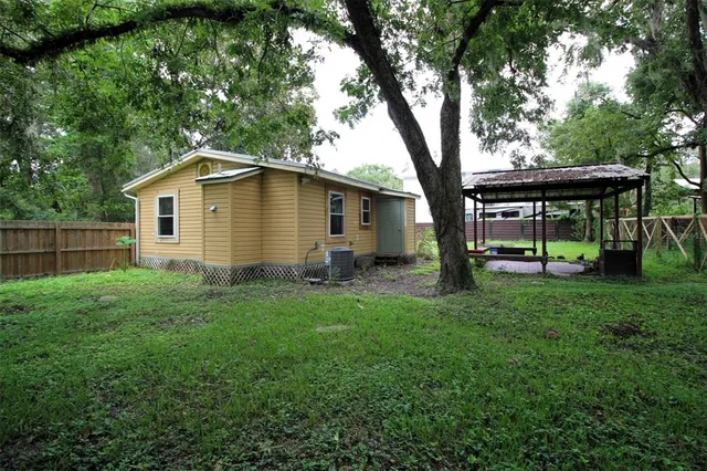 a view of a house with backyard and a tree