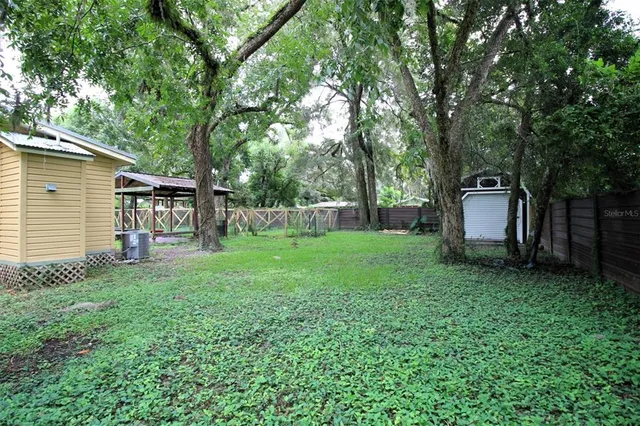 a view of a house with backyard and a tree
