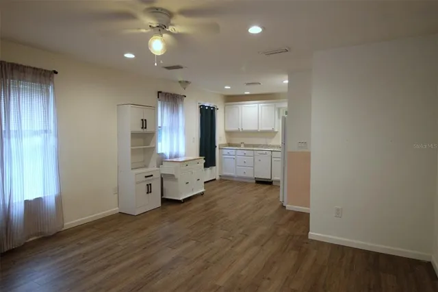 a view of a kitchen with wooden floor and a window