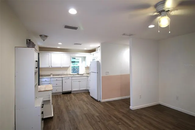 a kitchen with kitchen island white cabinets and stainless steel appliances