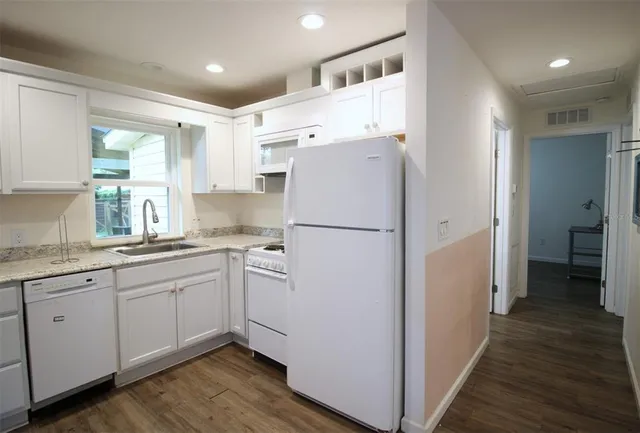 a kitchen with refrigerator cabinets and wooden floor