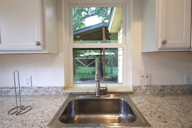 a kitchen with granite countertop a sink and a window