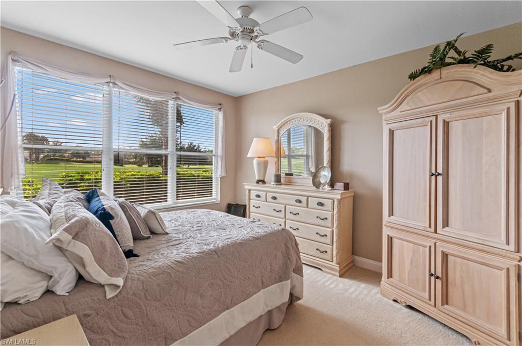 9030 Spring Run Boulevard, Unit 507 Estero, FL 34135 - Photo 15 of 21 a bedroom with a bed a dresser next to a large window