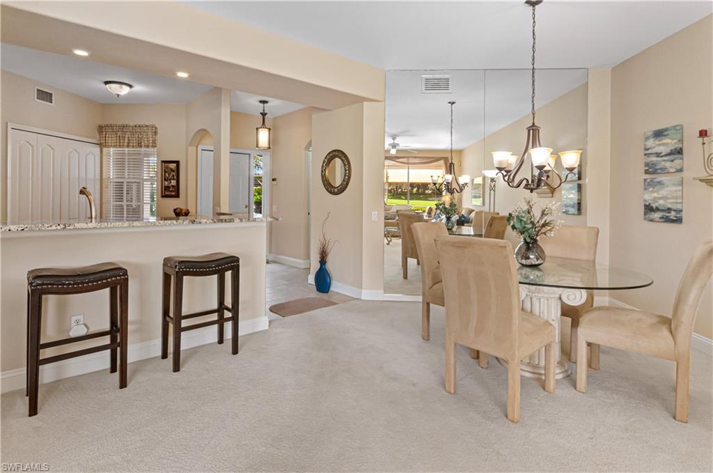 9030 Spring Run Boulevard, Unit 507 Estero, FL 34135 - Photo 10 of 21 a dining room filled a chandelier and kitchen view