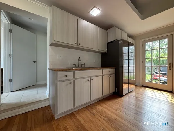 a kitchen with a sink wooden floor and stainless steel appliances