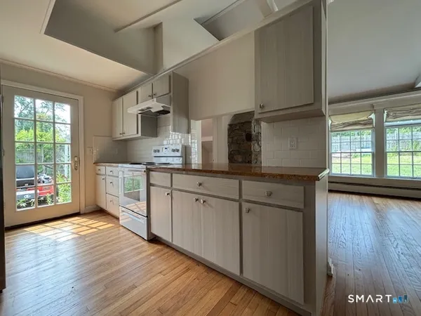 a kitchen with stainless steel appliances granite countertop a sink cabinets and wooden floor